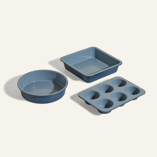 The Wonder Oven Baker’s Kit includes three blue non-toxic baking pans—a round, a square, and a six-cup muffin tin—arranged on a light background, perfect for your Wonder Oven.