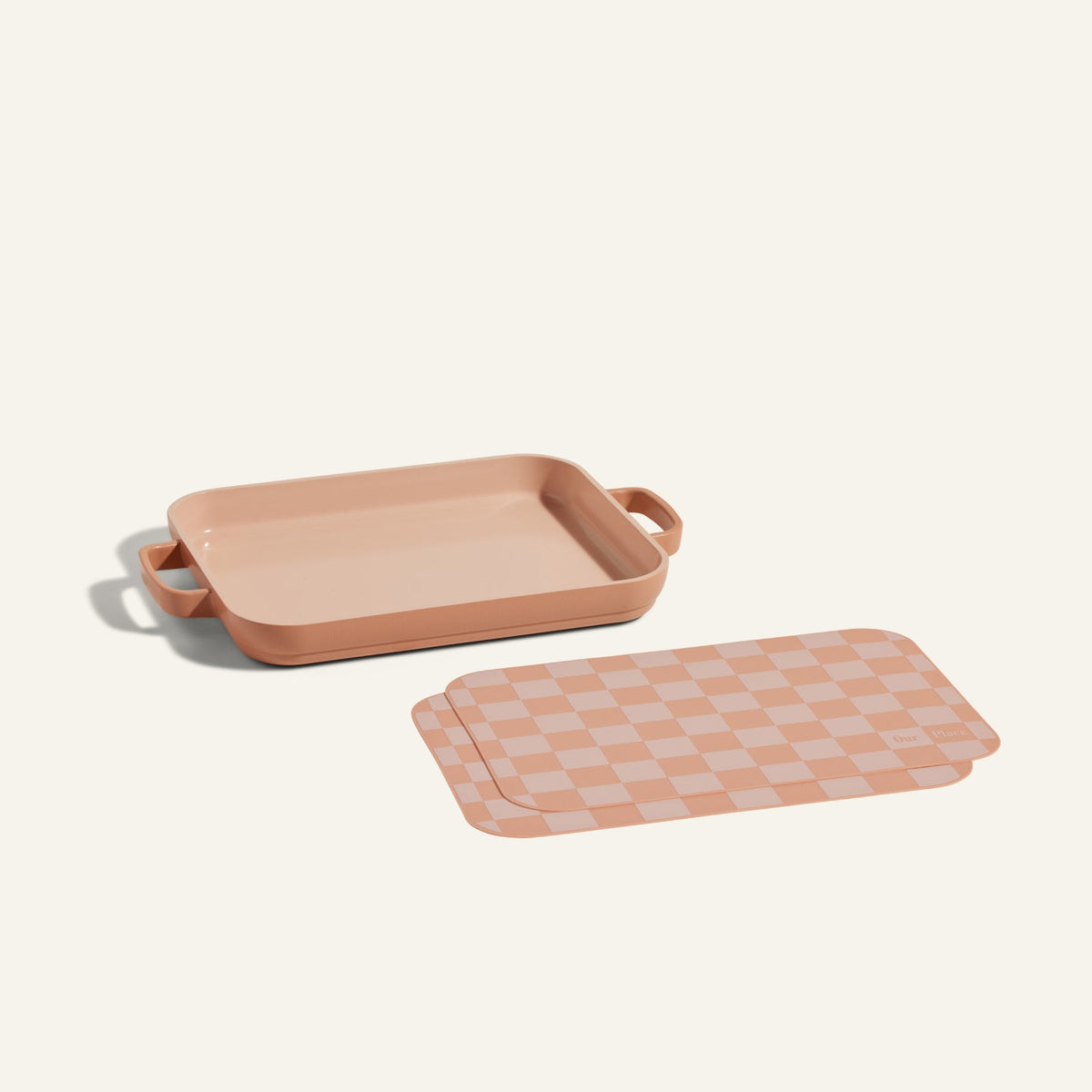 A Mini Griddle Pan with handles is displayed beside matching Mini Oven Mats on a plain background.
