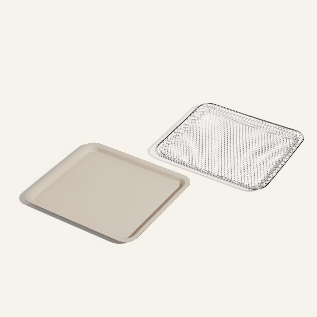 The Wonder Oven Essentials Kit includes a beige rectangular baking tray and a silver wire cooling rack, ideal for doubling recipes, shown side by side on a light background.