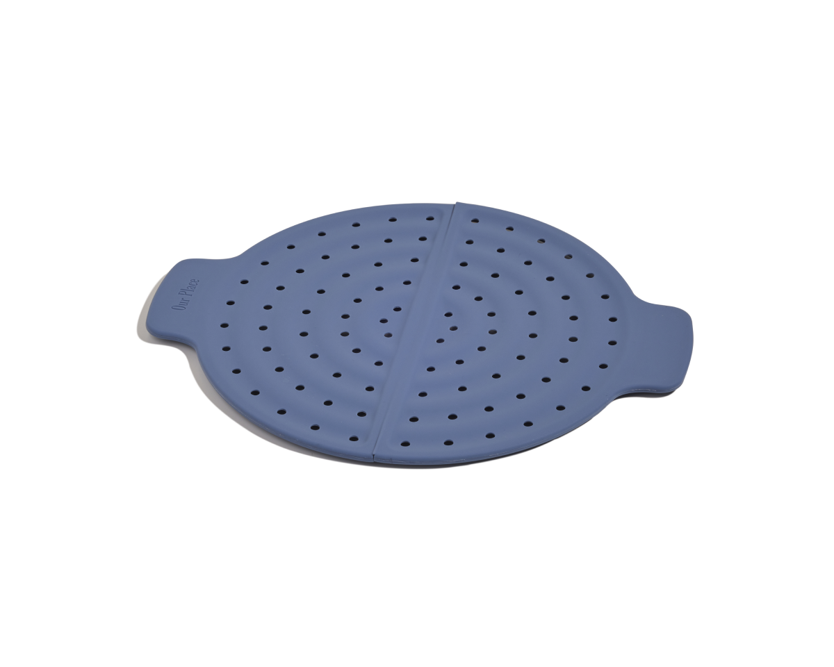 The Fearless Fry is a round blue silicone steamer insert with side handles and evenly spaced holes, designed for splatter prevention and the perfect companion to your Always Pan.