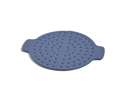 The Fearless Fry is a round blue silicone steamer insert with side handles and evenly spaced holes, designed for splatter prevention and the perfect companion to your Always Pan.
