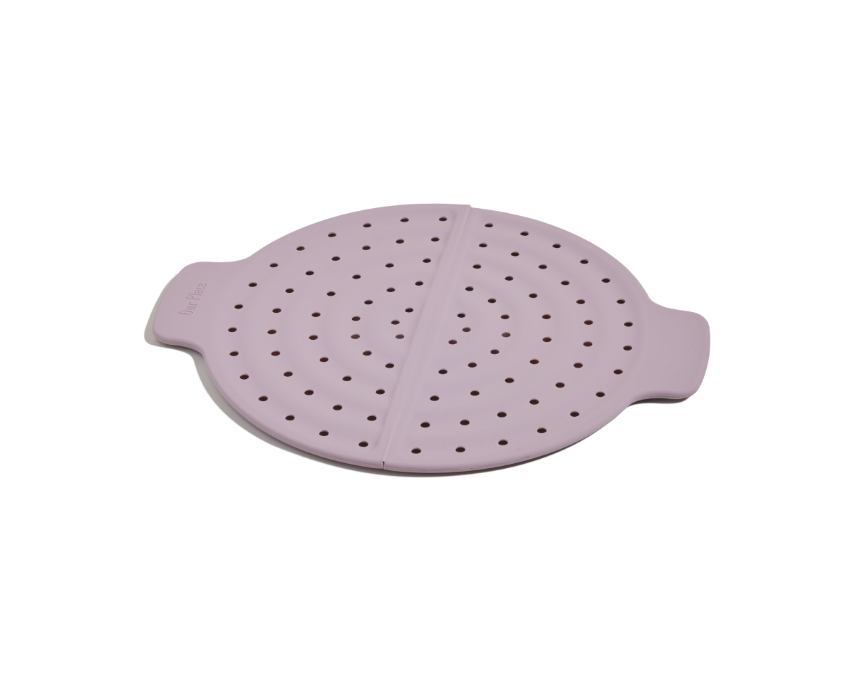 The Fearless Fry is a round, light purple silicone steamer basket with two handles and evenly spaced holes, designed to prevent splatter when used with the Always Pan. Displayed on a white background.