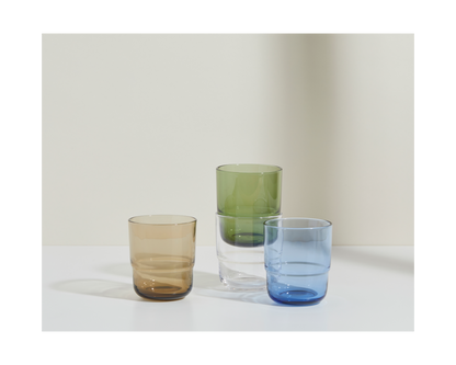 The Short Night + Day Glasses set features four handmade tumblers—brown, clear, green, and blue—crafted from recycled glass for a stylish, sustainable accent to any space.