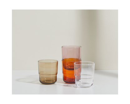 The Short Night + Day Glasses—brown, pink, and clear—crafted from recycled glass tumblers, are arranged on a white surface against a neutral background.