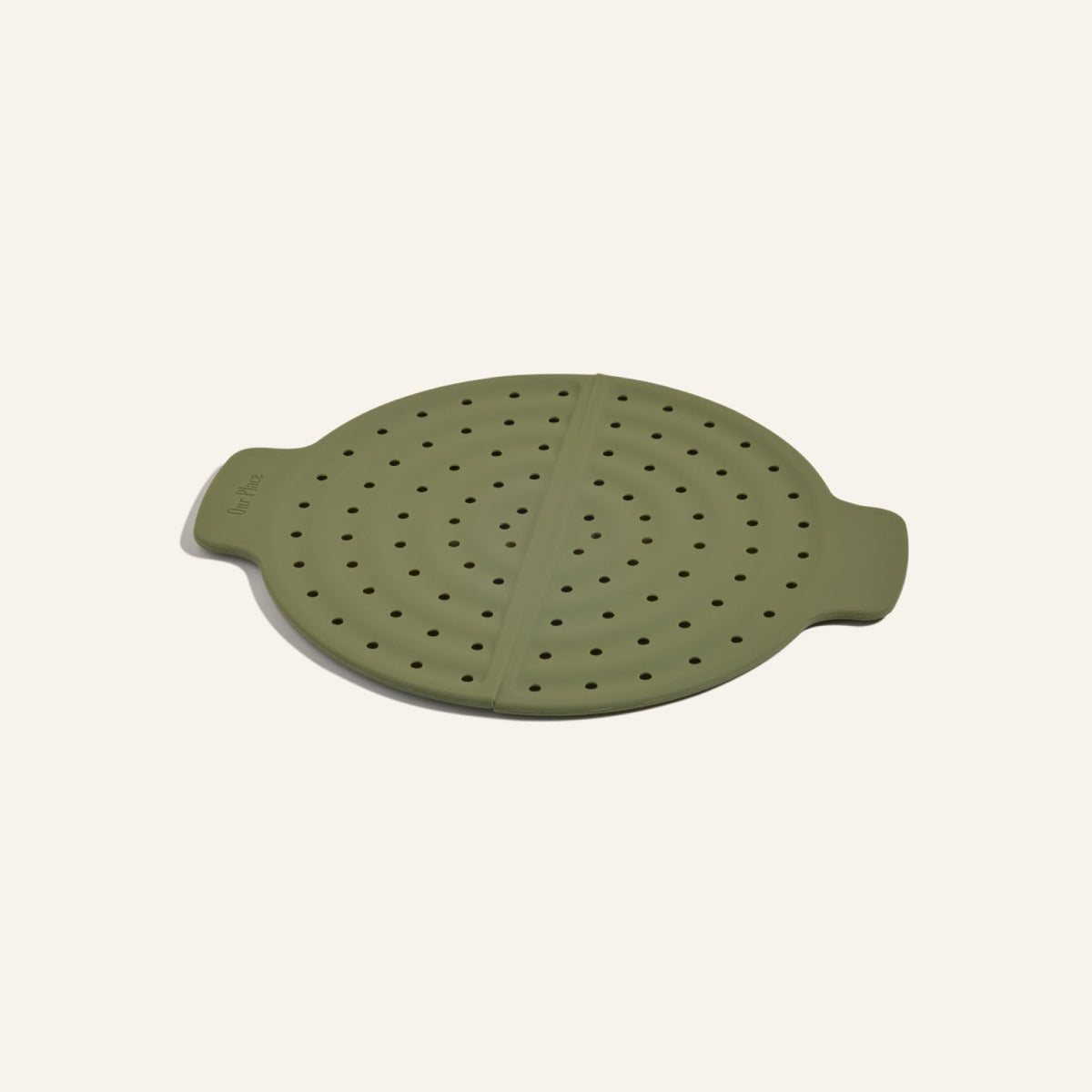The Fearless Fry is a round, green silicone steamer lid with dual handles and evenly spaced holes to prevent splatter—perfect for use with your Always Pan.