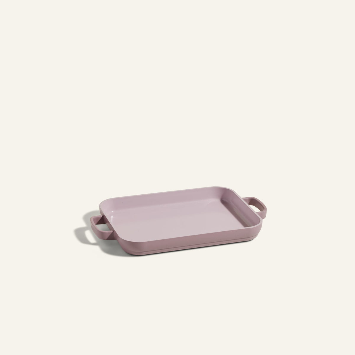 Light purple Mini Griddle Pan, rectangular ceramic with handles on both sides, similar in size to a quarter sheet pan, displayed on a plain light background.