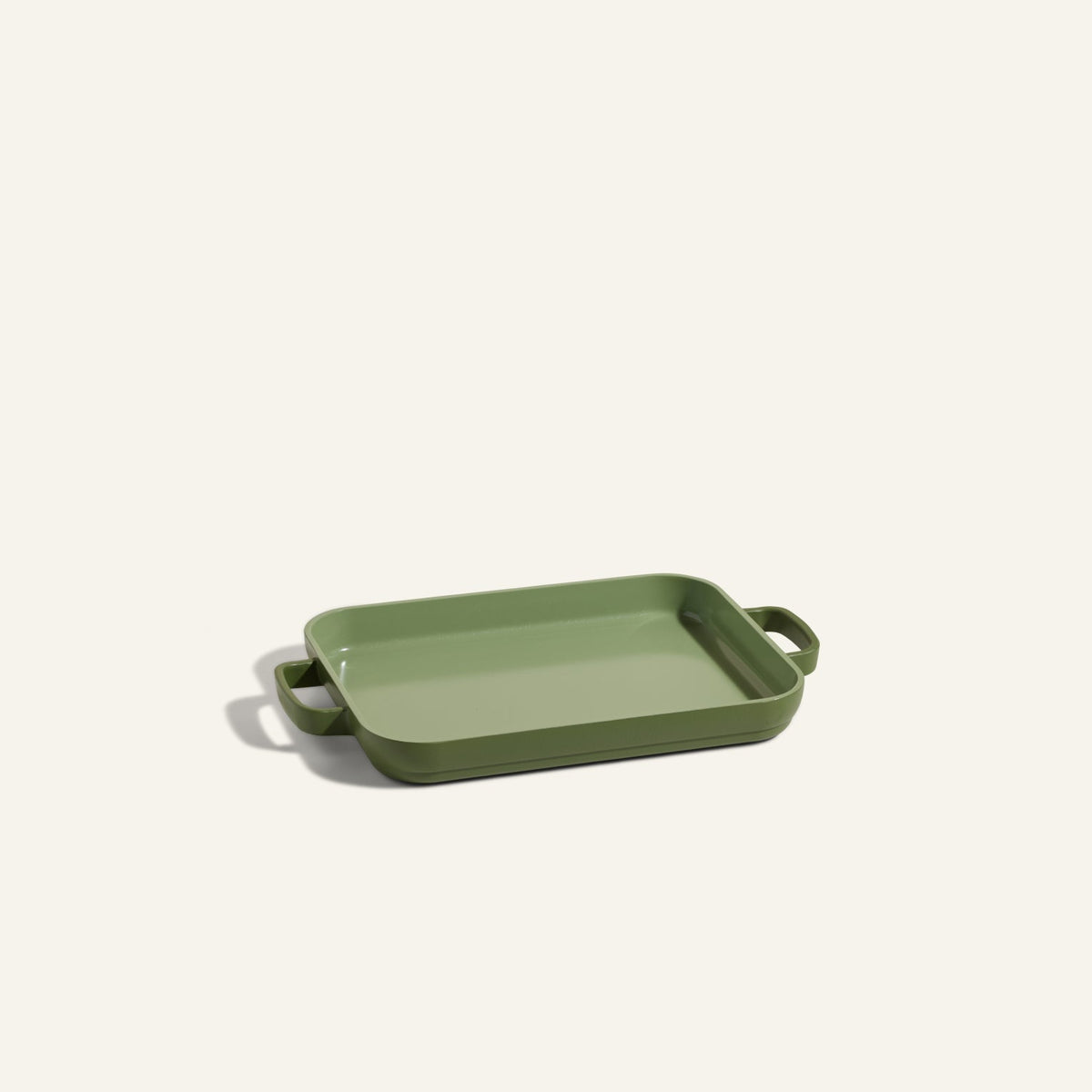 A Mini Griddle Pan, featuring a rectangular green nonstick design with two handles, is set on a plain light background.