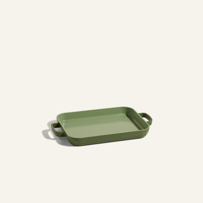 A Mini Griddle Pan, featuring a rectangular green nonstick design with two handles, is set on a plain light background.