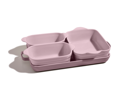 The Bakeware Set includes four stacked pink ceramic baking dishes in different sizes, ideal for any modern kitchen.