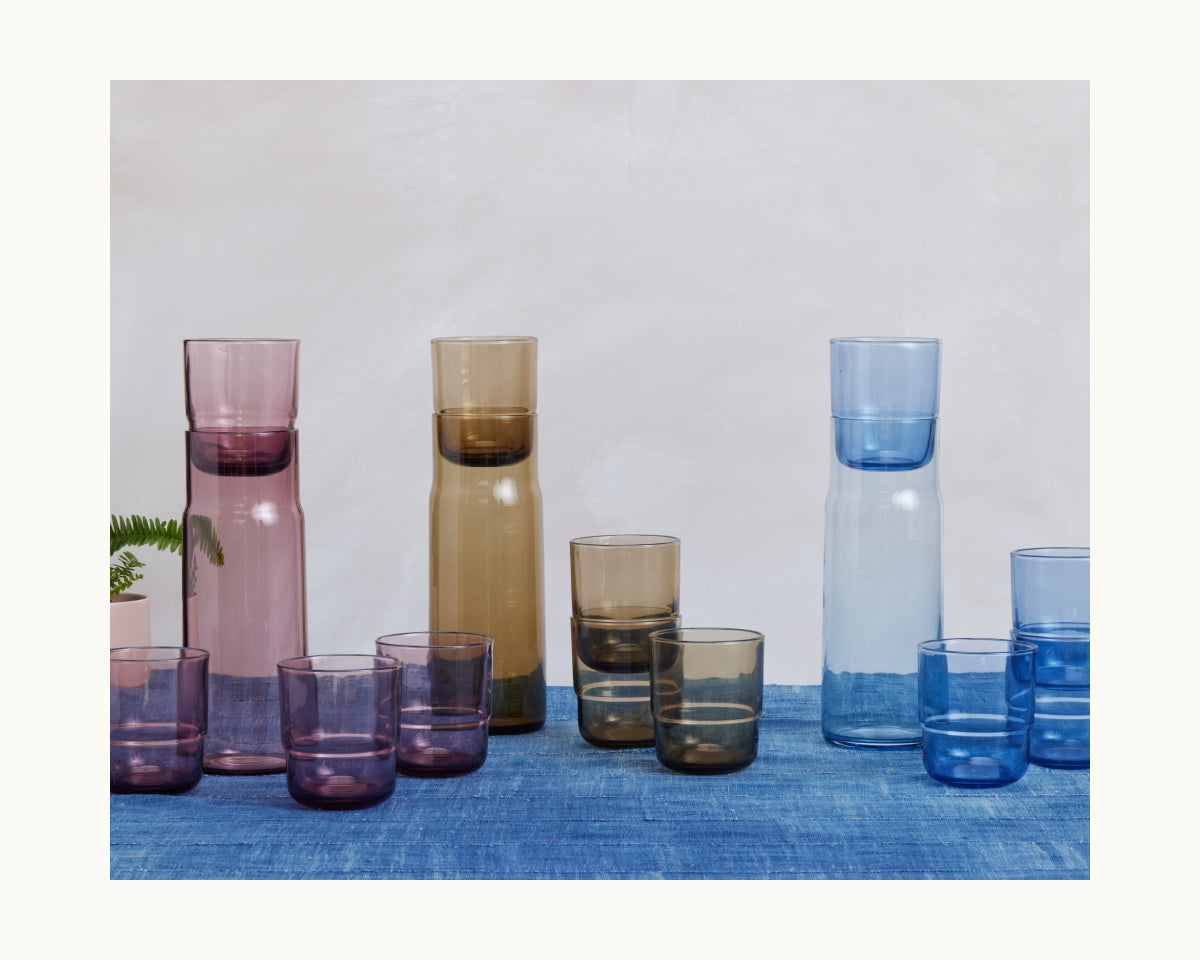 Three Night + Day Carafe sets with matching tumblers, ideal as wine aerators, are arranged on a blue surface against a light backdrop.