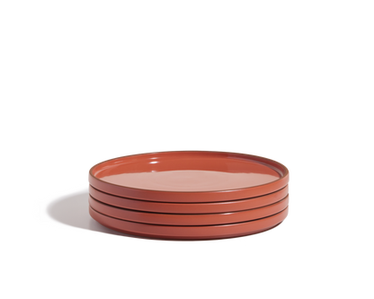 A stack of four round, red hand-glazed Dinner Plates on a white background—perfect for adding a vibrant touch to your tableware collection.