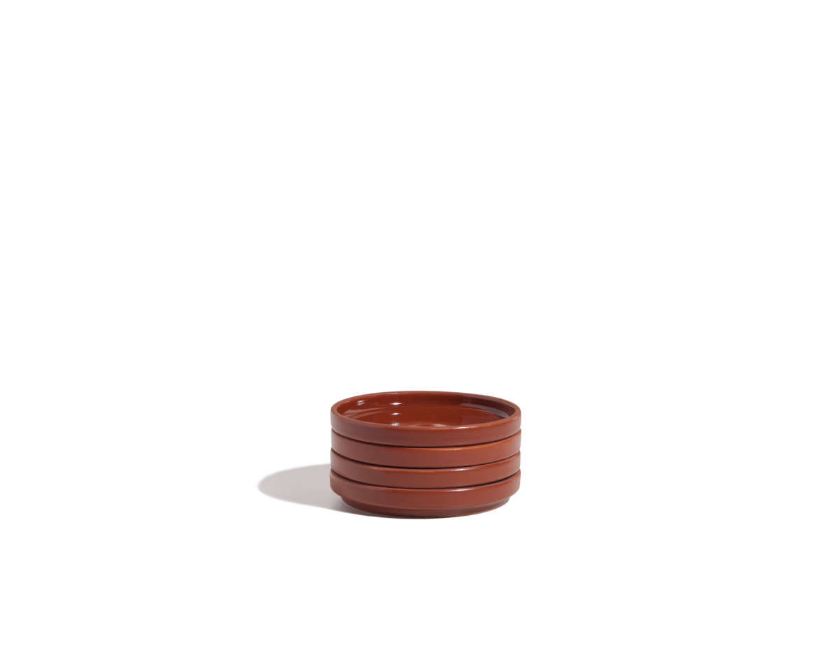 A small stack of three round, brown Tiny Plates ceramic snack plates is placed on a plain white background.
