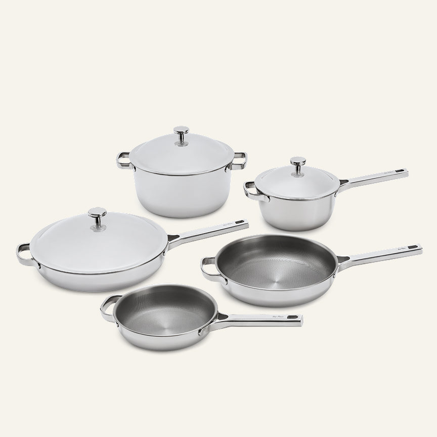 A set of five Titanium Pro Cookware Set+ 2.0 stainless steel pots and pans, some with matching lids.