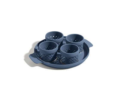 The Egg Poacher features four blue perforated silicone cups in a round tray, ideal for making poached eggs. Shown on a white background.