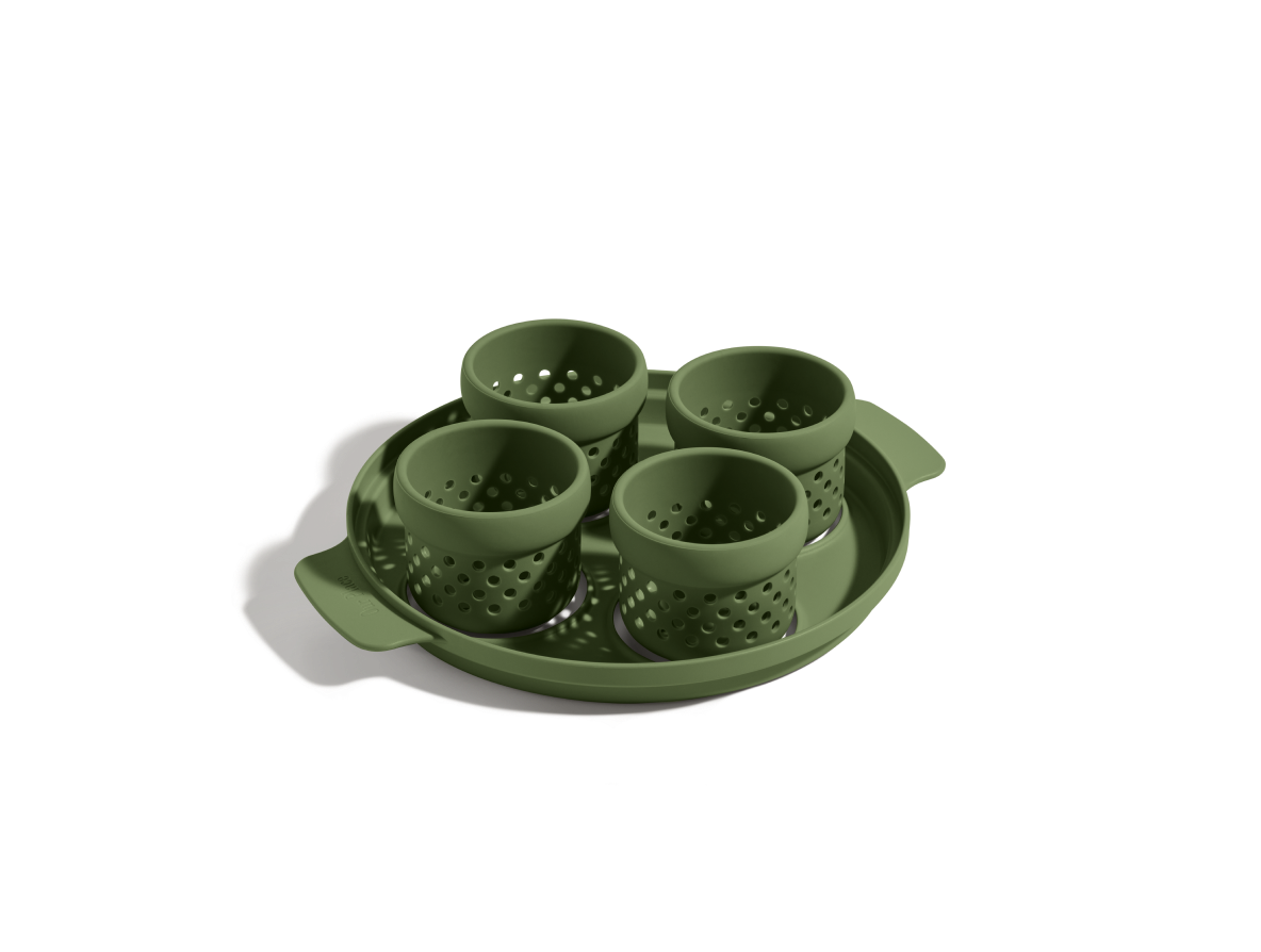 The Egg Poacher includes four green silicone cups in a matching round handled tray, perfect for steaming or cooking poached eggs, shown on a white background.