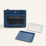 The Wonder Oven Pro + Wonder Oven Pro Essentials Kit features a blue countertop oven with a digital display, shown alongside a matching blue baking tray and a metal wire rack positioned in front.