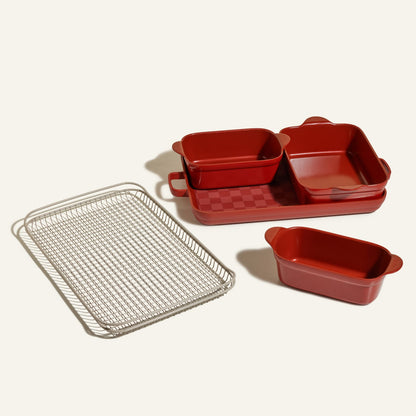 The Bakeware Set is a 5-piece collection with red ceramic baking dishes in assorted sizes and a silver wire cooling rack, displayed on a light surface.